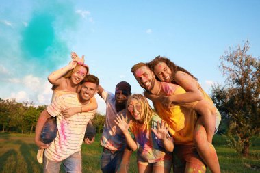 Açık havada renkli pudra boyalarıyla kaplanmış mutlu arkadaşlar. Holi festivali kutlaması