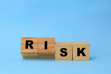 Sözcüklerle ahşap küpleri Açık mavi arka planda risk