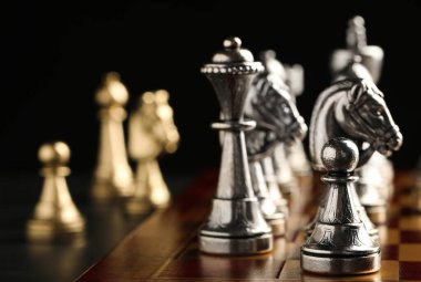 Siyah arkaplanda oyun taşları olan satranç tahtası, yakın plan