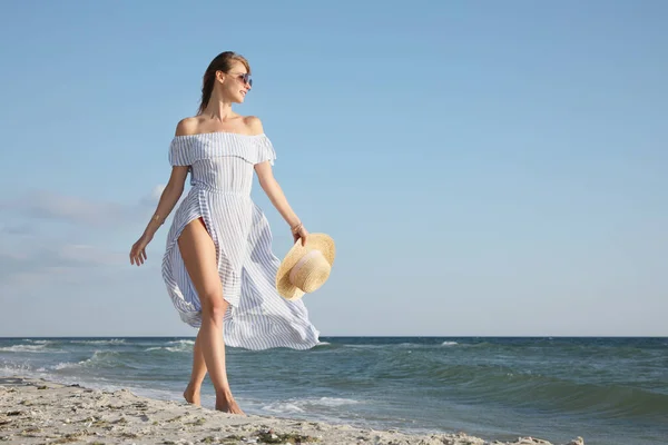 Hasır Şapkalı Bir Kadın Güneşli Bir Günde Deniz Kenarında Yürüyor — Stok fotoğraf