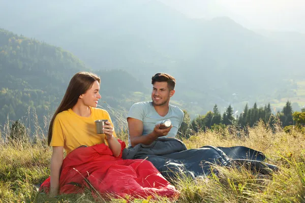 Glückliches Paar Mit Getränken Schlafsäcken Umgeben Von Wunderschöner Natur — Stockfoto