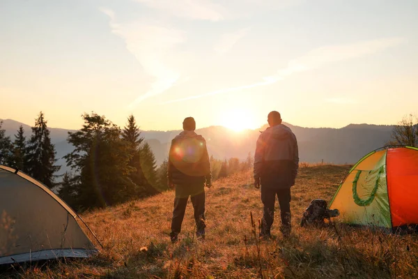 Mężczyźni Pobliżu Namiotów Kempingowych Górach Zachodzie Słońca Widok Tyłu — Zdjęcie stockowe