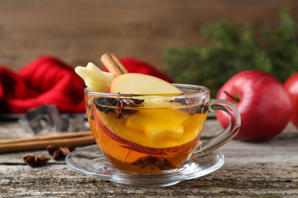 Hot mulled cider on wooden table, closeup