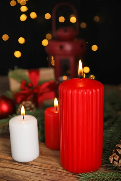 Brandende Kaarsen Kerstdecor Houten Tafel Tegen Wazig Feestelijk Licht — Stockfoto