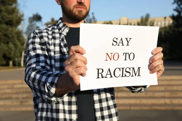 手持标语的年轻人在户外对种族主义说不 特写镜头 — 图库照片