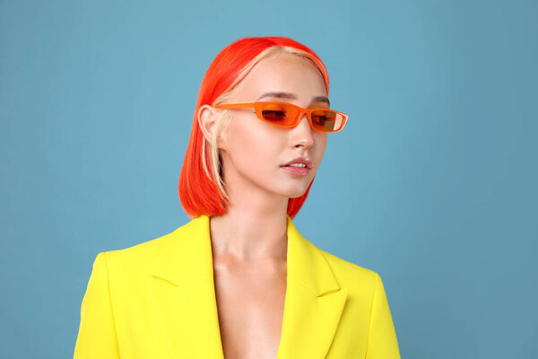 Красивая молодая женщина с яркими окрашенными волосами на бирюзовом фоне