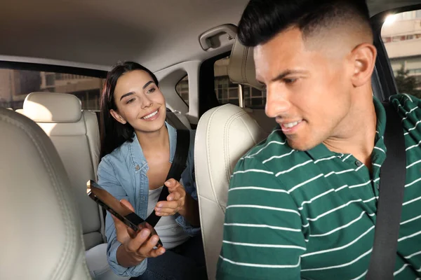 Jovem Mostrando Smartphone Para Motorista Táxi Carro Moderno — Fotografia de Stock