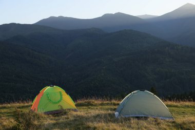 Dağlardaki tepede iki renkli kamp çadırı