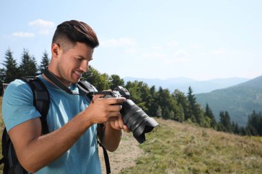 Dağlarda modern kamerası olan profesyonel bir fotoğrafçı. Metin için boşluk