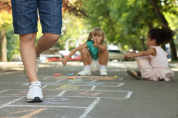 Małe Dzieci Bawiące Się Hopscotch Rysowane Kredą Zewnątrz Asfaltu Zbliżenie — Zdjęcie stockowe