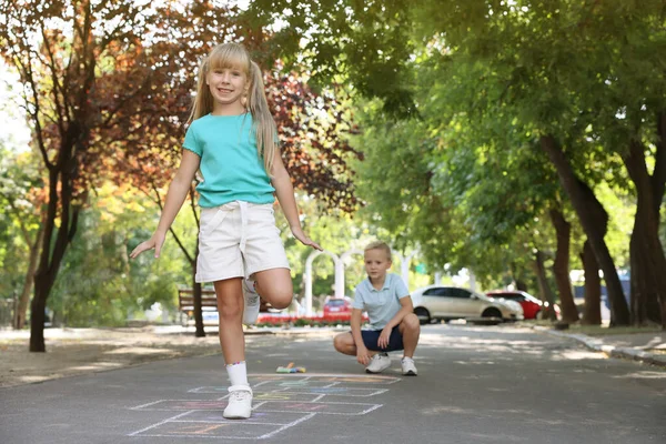 小孩子们在室外用粉笔在沥青上玩跳跳 — 图库照片