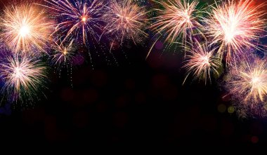 Güzel, parlak havai fişekler gece gökyüzünü aydınlatıyor. 