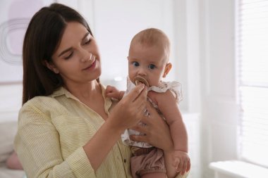 Mutlu anne küçük bebeğine emzik veriyor.