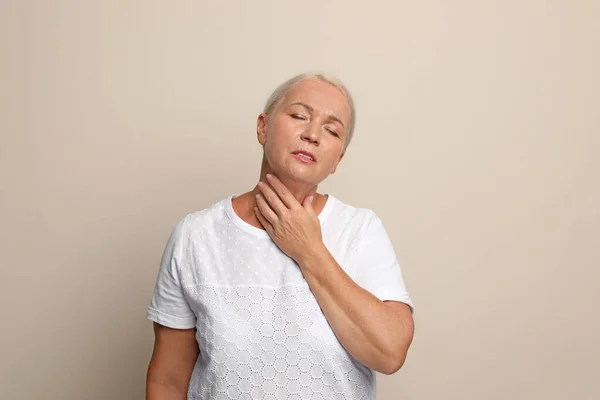 Mature Woman Doing Thyroid Self Examination Beige Background — Stock Photo, Image