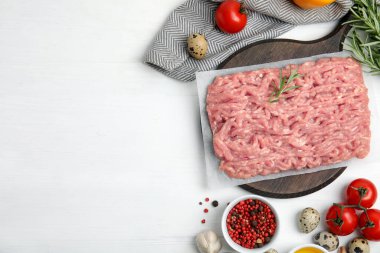 Çiğ tavuk kıyma ve malzemeler beyaz ahşap masa üzerinde, düz yatıyordu. Metin için boşluk