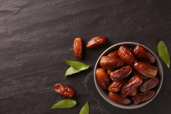 Tasty Sweet Dried Dates Green Leaves Black Table Flat Lay — Stock Photo, Image