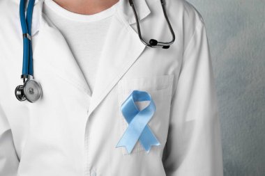 Açık mavi farkındalık kurdeleli doktor, yakın plan.