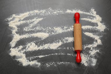 Siyah masa üzerinde yuvarlak iğne ve un, üst manzara. Metin için boşluk