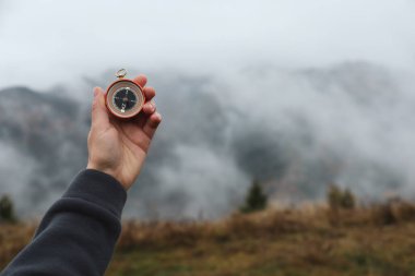 Dağlarda yolculuk yaparken pusula kullanan bir kadın, yakın plan. Metin için boşluk