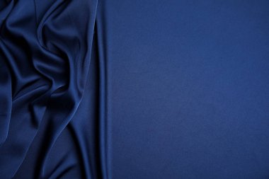 Arka plan olarak buruşmuş koyu mavi ipek kumaş, üst manzara. Metin için boşluk