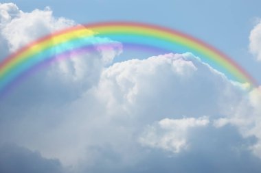 Mavi gökyüzünde güzel gökkuşağı güneşli bir günde beyaz bulutlar