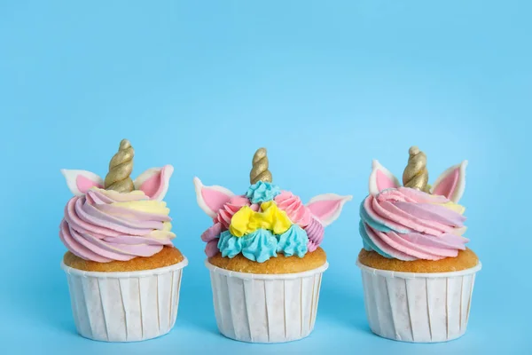 Τρία Χαριτωμένα Γλυκά Cupcakes Μονόκερου Γαλάζιο Φόντο — Φωτογραφία Αρχείου