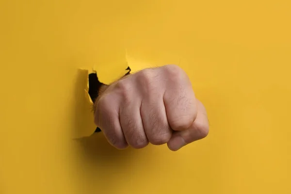 Mann Durchbricht Gelbes Papier Mit Faust Nahaufnahme — Stockfoto