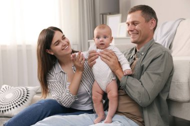 Mutlu bir aile ve tatlı bebekleri oturma odasında yerde.