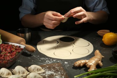 Gri masada gyoza yapan kadın, yakın plan.