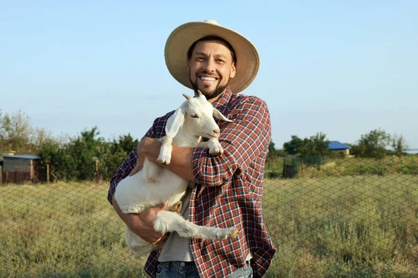 Man with goat at farm. Animal husbandry