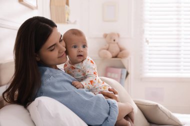 Anne evde tatlı bebeğiyle yatıyor.