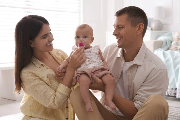 快乐的夫妇抱着他们可爱的小宝宝在家里用奶嘴 — 图库照片
