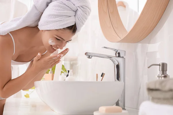 バスルームでクレンジングフォームで美しい十代の女の子の顔を洗う スキンケア化粧品 — ストック写真