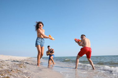 Su tabancalı arkadaşlar sahilde eğleniyor.