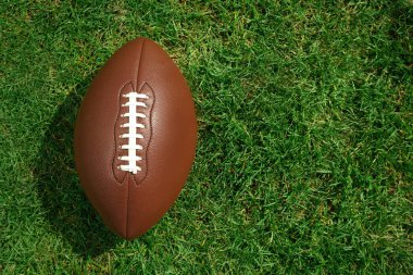 Yeşil çimlerin üzerinde Amerikan futbol topu, üst manzara. Metin için boşluk