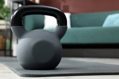 Kettlebell ve gri yoga minderi odada. Metin için boşluk