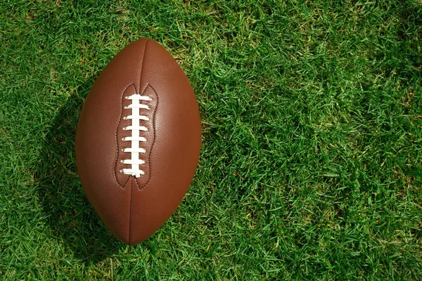 緑の芝生の上でアメリカンフットボールボール トップビュー テキストのスペース — ストック写真