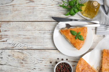 Beyaz ahşap masada servis edilen nefis etli turta. Metin için boşluk