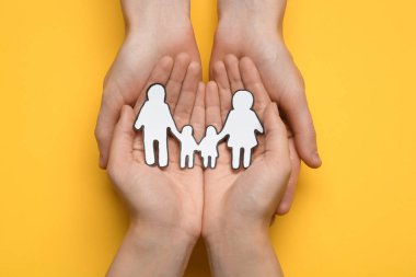 Sarı arka planda kağıt aile kesimi olan çift, üst manzara.