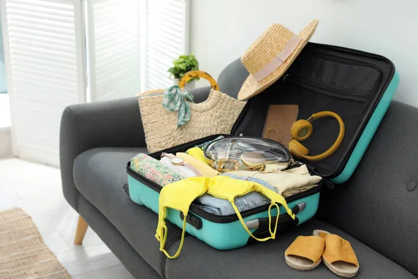 Offener Koffer Voller Kleidung Schuhe Und Sommeraccessoires Auf Sofa Zimmer — Stockfoto