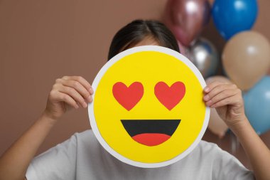 Süslü odada kalbi olan küçük bir kız emojisi.