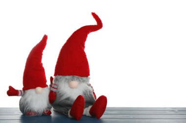 Mavi ahşap masada beyaz arka planda komik noel cüceleri. Metin için boşluk