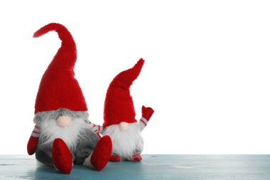 Turkuaz ahşap masada beyaz arka planda komik noel cüceleri. Metin için boşluk