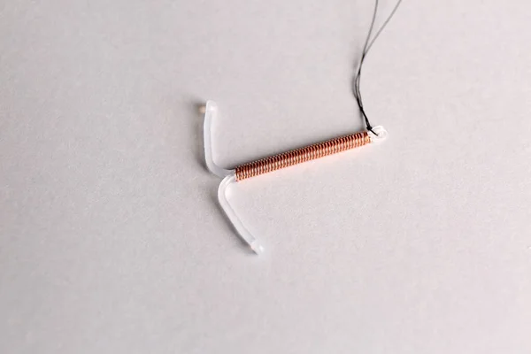 光を背景にしたT字型子宮内避妊具 — ストック写真