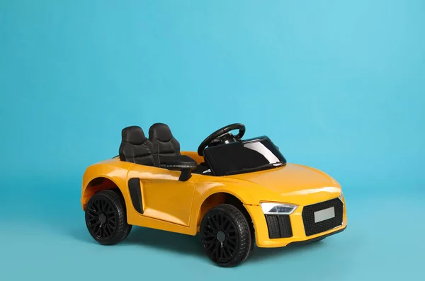 Açık Mavi Arka Planda Küçük Sarı Bir Araba Çocuk Oyuncağı — Stok fotoğraf