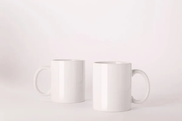 薄い背景に空白の白いセラミックマグカップ — ストック写真