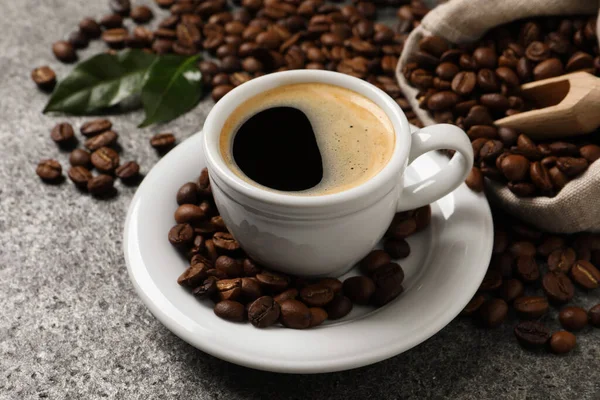 Tasse Aromatischer Heißer Kaffee Und Bohnen Auf Grauem Tisch — Stockfoto