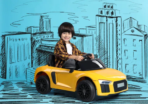 Schattig Jongetje Rijden Speelgoed Auto Tekening Van Stad Lichtblauwe Achtergrond — Stockfoto