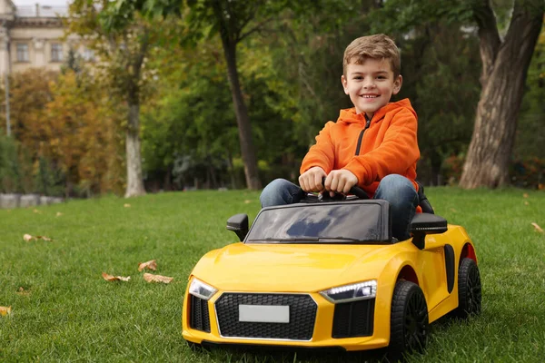 公園で子供の車を運転するかわいい男の子 テキストのスペース — ストック写真