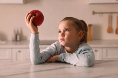 Mutfakta elma yemeyi reddeden tatlı küçük kız.